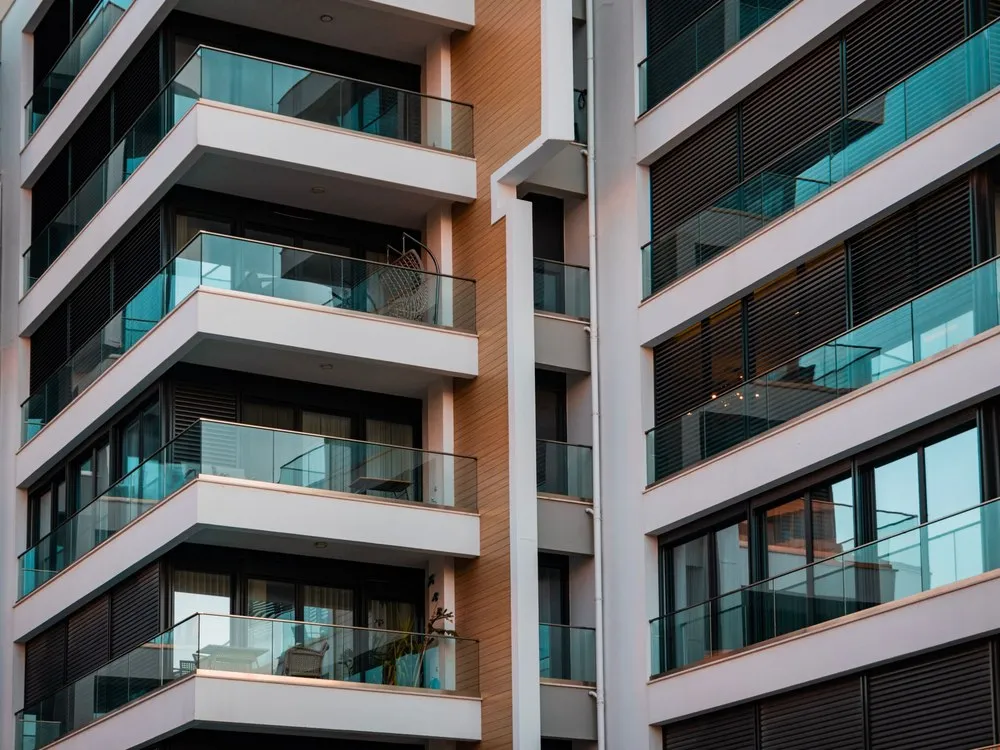 Gedung apartemen dengan balkon lebar berpagar kaca