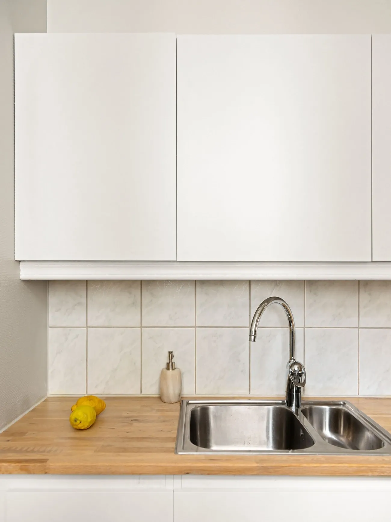 Dapur putih dengan meja kayu dan wastafel
